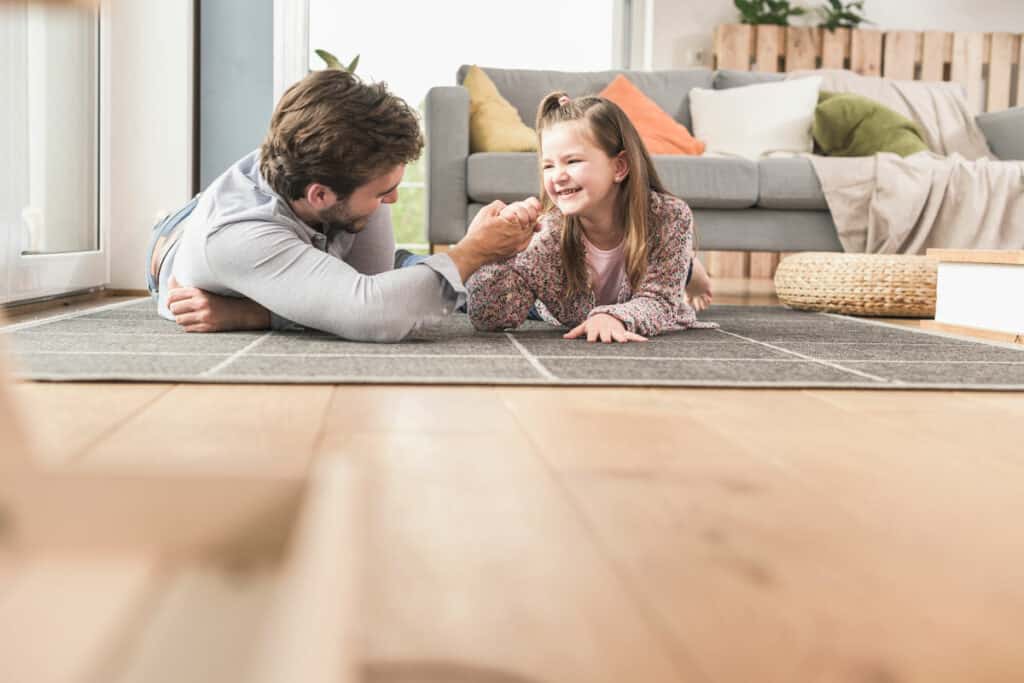 père et fille jouent au sol